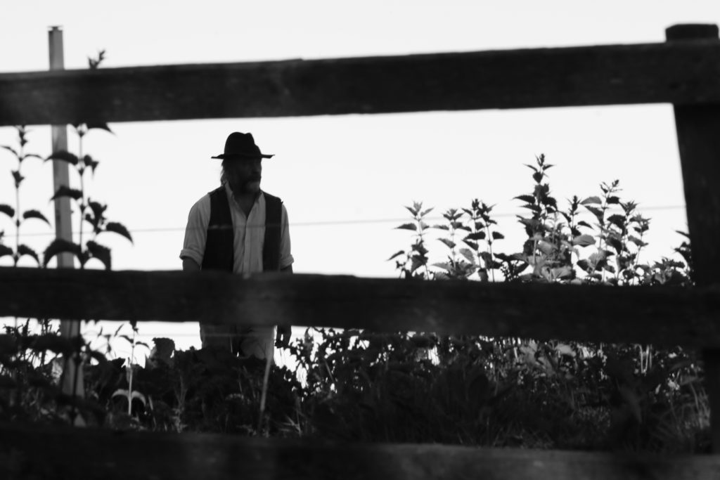 Man with hat approaching fence