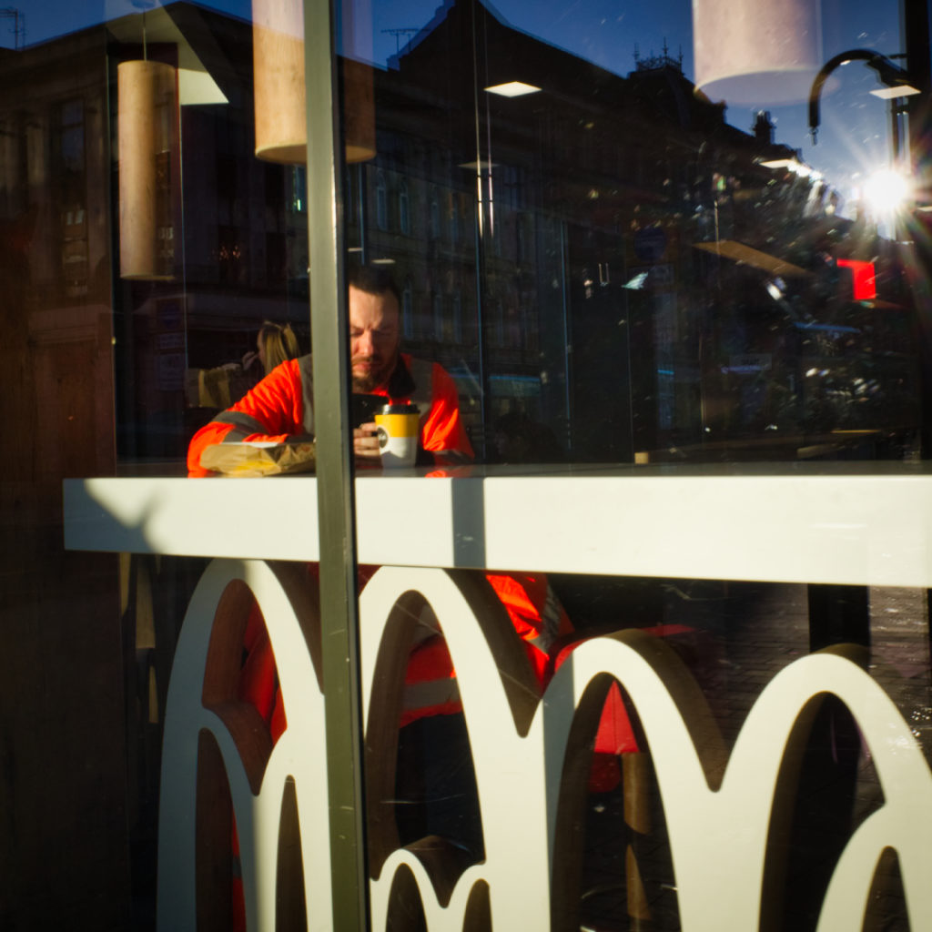 Workman drinking coffee in MacDonalds, Leeds