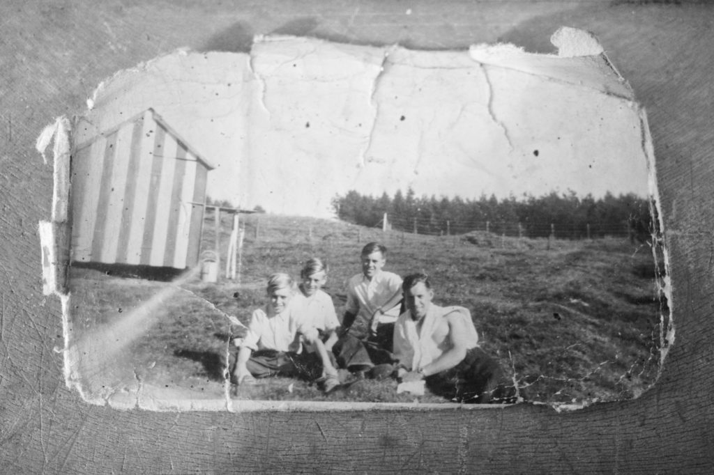 Howard Jackson (third from left) with pigeon loft in background