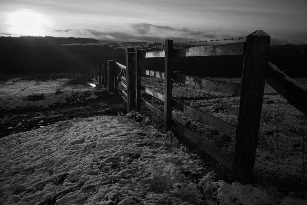 Wooden fence and barbed wire, black and white photograph, North York Moors