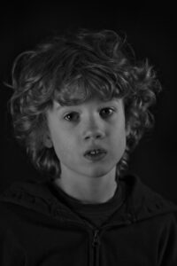 Black and white portrait of young boy with curly hair