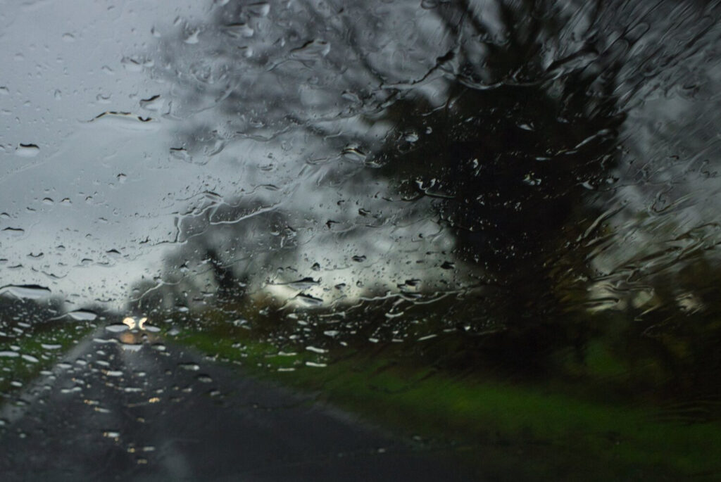 Photo created of road and car lights taken in rainstorm through car windscreen