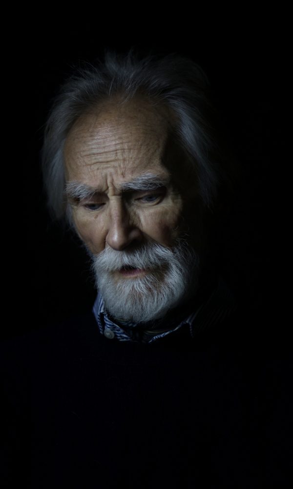 Portrait of older man with white beard looking down - headshot